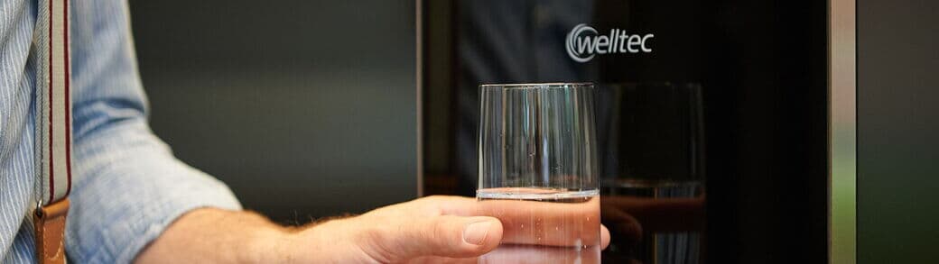 Mann nimmt sich Glas Wasser