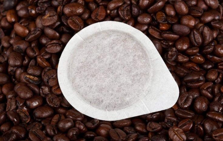 Kaffeepad liegt auf einem Haufen Kaffeebohnen