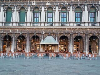 Leeres Caffè Florian mit Stühlen vor historischem Gebäude in Venedig