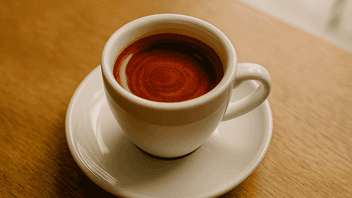 God Shot: Perfekter Espresso mit Tigerstreifen in weißer Tasse auf Holztisch