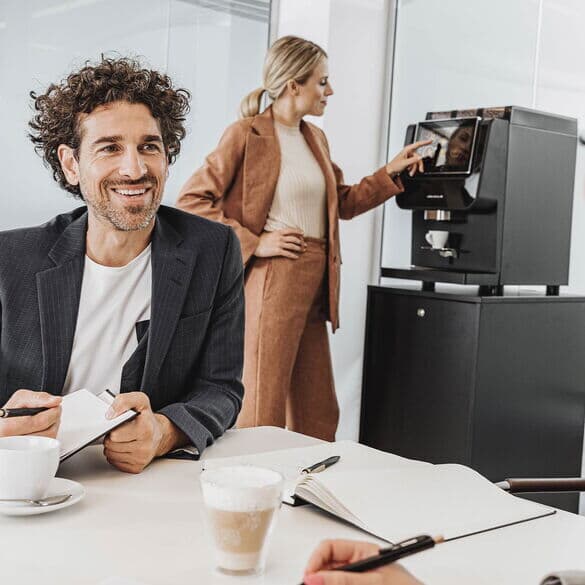 Kollegen-in-besprechung-mit-kaffeevollautomat