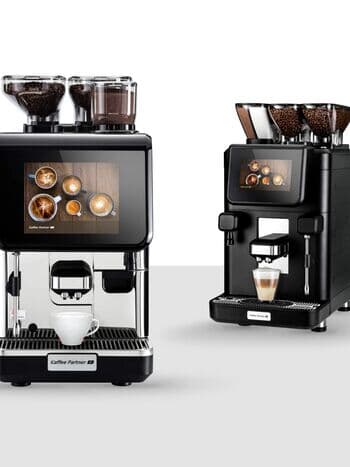 Nahaufnahme von zwei professionellen Kaffeevollautomaten mit doppelten Bohnenbehältern für verschiedene Kaffeesorten, die Geschmacksvielfalt garantieren.