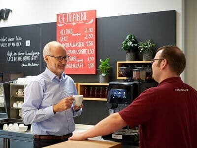 Techniker hilft Kaffee Partner-Kunden