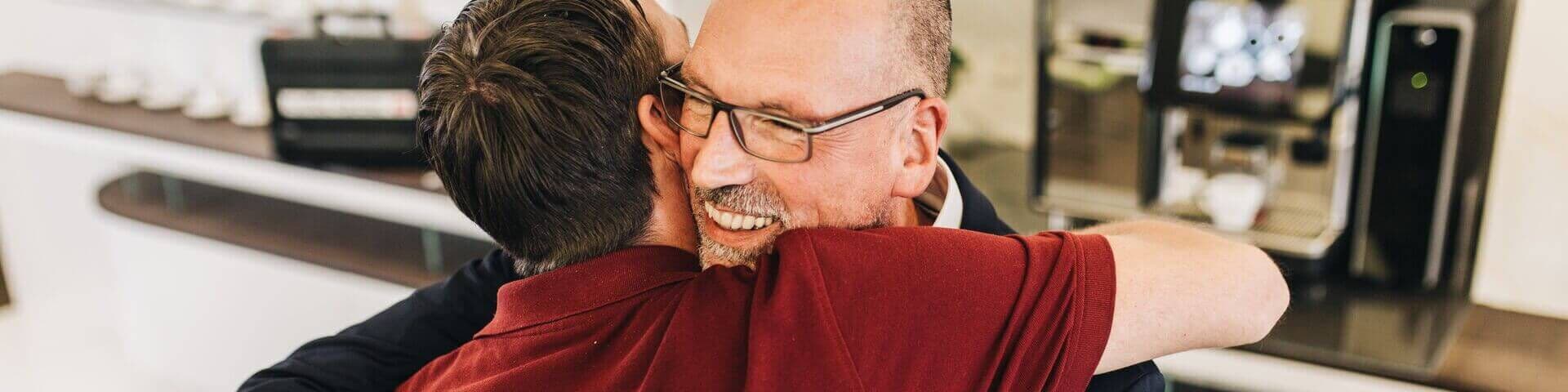 Kunde umarmt dankbar einen Service-Mitarbeiter