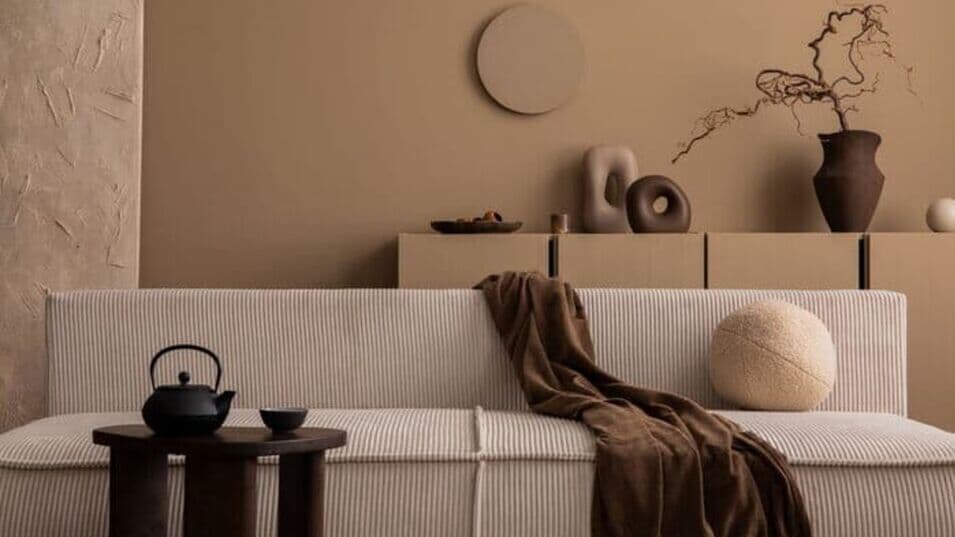 Minimalistisches Wohnzimmer mit beigem Sofa und stilvoller Deko in verschiedenen Kaffeefarben