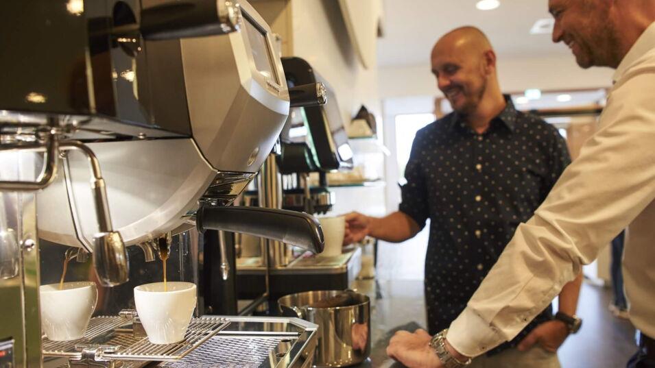 Kollege zieht sich Kaffee am Automaten