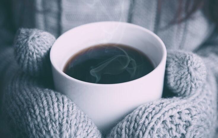 Eine Kaffeetasse in den Händen