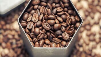 Nahaufnahme von Kaffeebohnen in einer sechseckigen Dose von oben