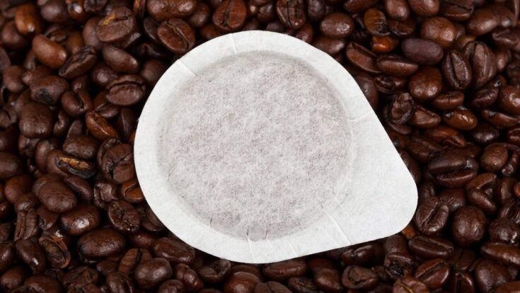 Kaffeepad liegt auf einem Haufen Kaffeebohnen