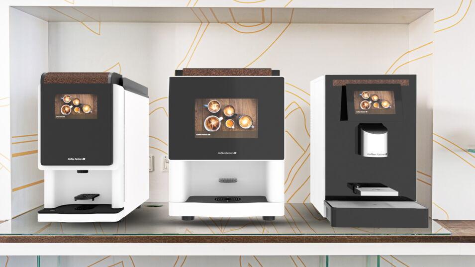 Die drei weißen Kaffeevollautomaten BARISTA Compact, multiBona3 und Crema Duo stehen nebeneinander in einer Kaffeebarnische