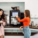 Zwei-frauen-interagieren-mit-ultima-duo-2-kaffeevollautomat