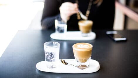 Espresso mit Wasser auf Tisch
