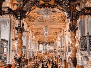Opulentes Café mit goldverzierter Decke und Kronleuchtern