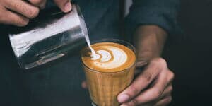 Barista mach Latte Art im Glas