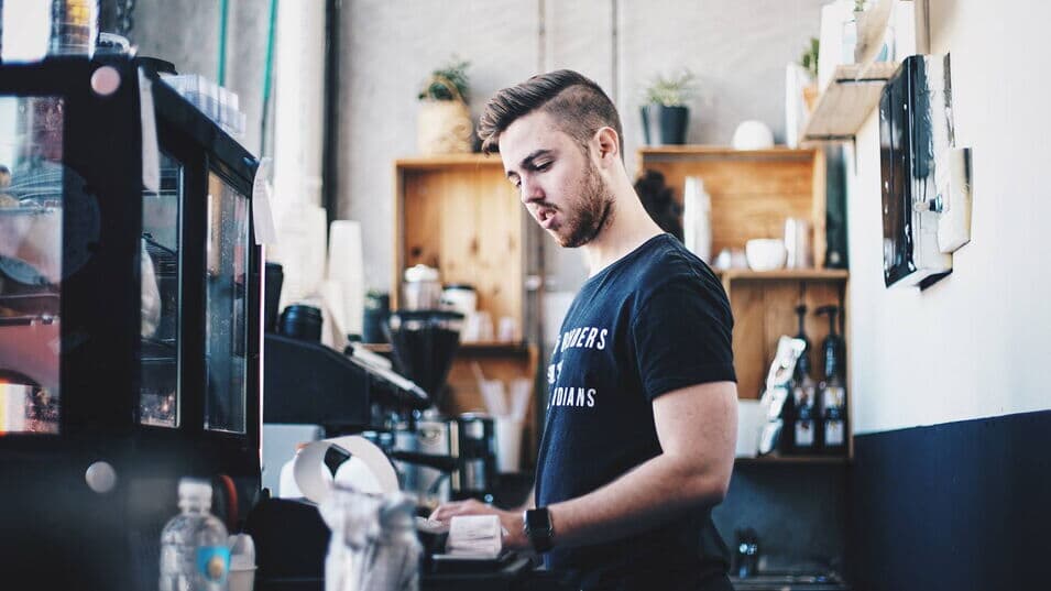 Barista steht an der Kasse