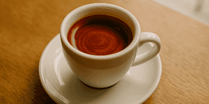 God Shot: Perfekter Espresso mit Tigerstreifen in weißer Tasse auf Holztisch
