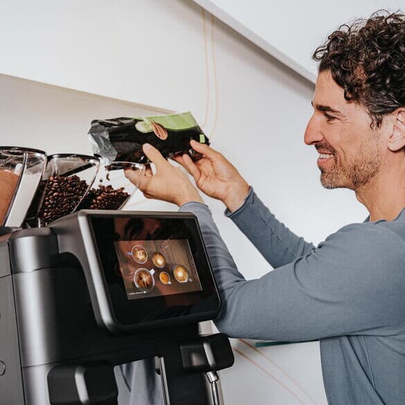 Person-füllt-kaffeebohnen-in-barista-ultima