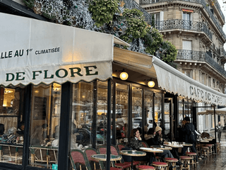 Menschen sitzen im Café de Flore bei winterlichem Wetter