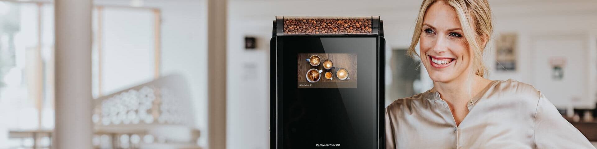 Frau neben Kaffeeautomaten-Modell Barista Compact
