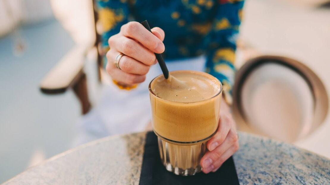Frau trinkt Frappé mit Strohhalm