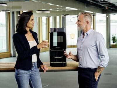 Mitarbeiter genießen Kaffee aus dem Kaffeevollautomaten Barista Select