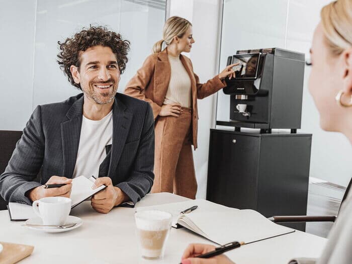 Kollegen-in-besprechung-mit-kaffeevollautomat