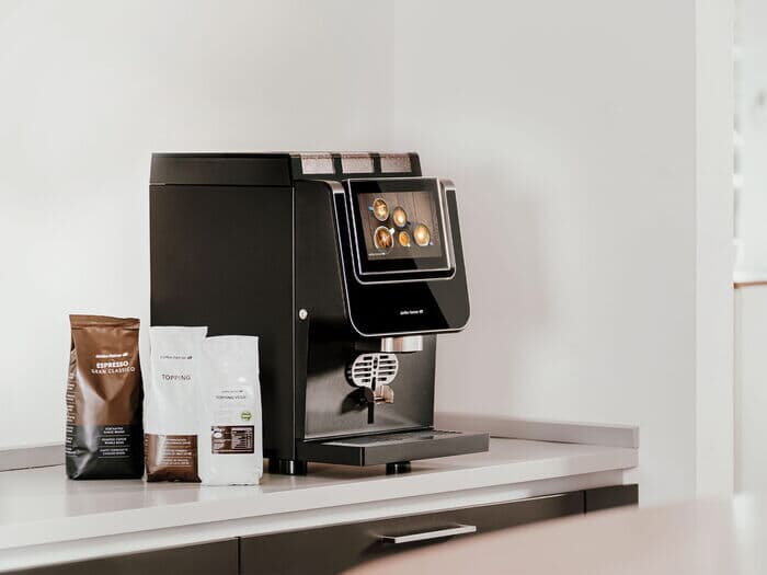 Barista-suprema-mit-kaffeebohnen-und-topping