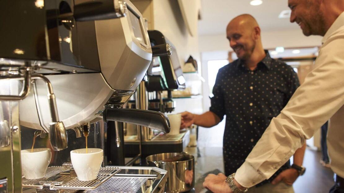 Kollege zieht sich Kaffee am Automaten