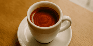 God Shot: Perfekter Espresso mit Tigerstreifen in weißer Tasse auf Holztisch