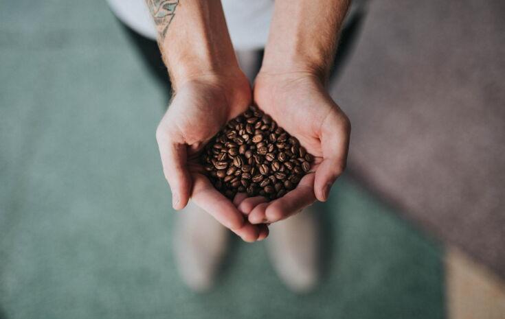 Kaffeebohnen gehalten von zwei Händen