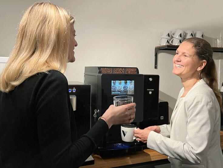 Bettina Stockhausen, Owner Venice Communications GmbH & Co. KG, unterhält sich in der Kaffeeküche bei einer Tasse Kaffee aus dem Kaffeevollautomaten BARISTA Compact