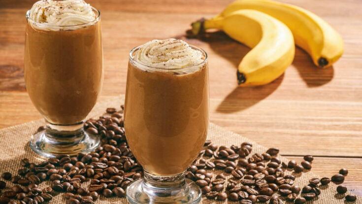 Zwei Kaffees auf einem Tisch neben Bananen und Kaffeebohnen