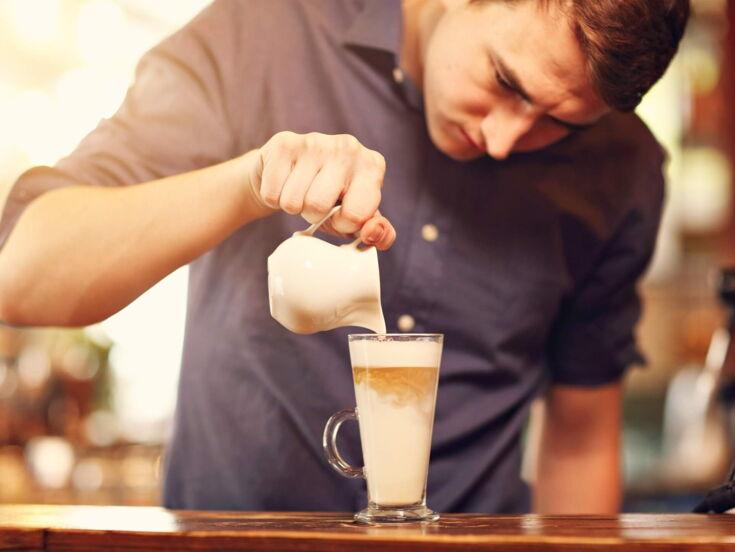 Mann gießt Espresso in Latte macchiato