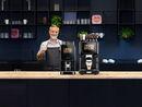 Barista präsentiert Kaffeevollautomaten von Kaffee Partner
