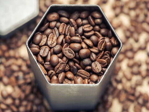 Nahaufnahme von Kaffeebohnen in einer sechseckigen Dose von oben