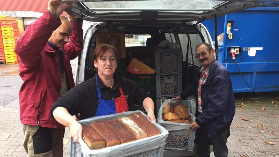 Helfer der Kindertafel laden die Essensspenden aus dem Wagen