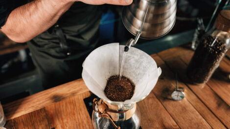 Wasser auf Kaffeemehl gießen in Chemex