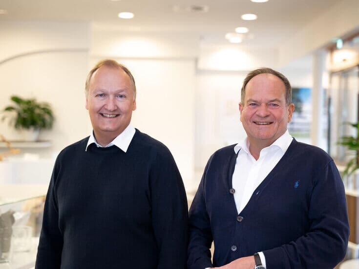 The two managing directors of Kaffee Partner Jorg Baumgart (CEO) & Roger Lang (CFO) stand side by side and smile into the camera