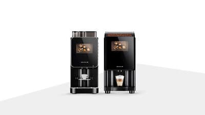 Zwei kompakte Kaffeeautomaten nebeneinander mit Bohnenbehältern und Kaffeespezialitäten auf dem Display.