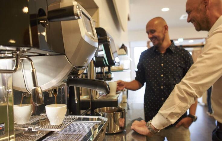 Kollege zieht sich Kaffee am Automaten