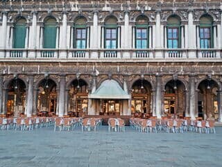 Leeres Caffè Florian mit Stühlen vor historischem Gebäude in Venedig