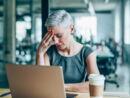 Frau hat Kopfschmerzen im Büro