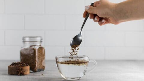 Frau rührt Instantkaffee in gekochtes Wasser