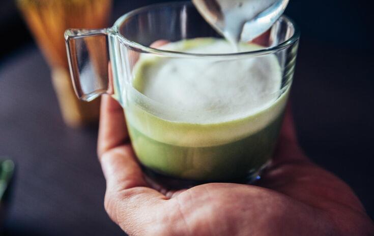 Mann hält Matcha Latte in Hand