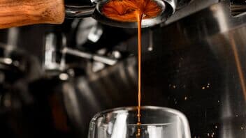 Frischer Espresso läuft in ein Glas