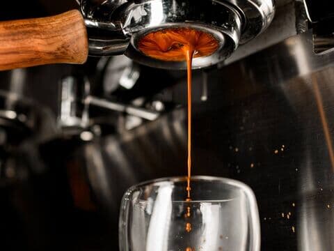 Frischer Espresso läuft in ein Glas