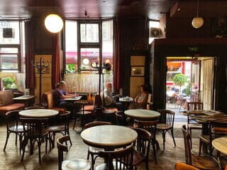 Café Hawelka mit Gästen und geöffneter Tür zum Gastgarten