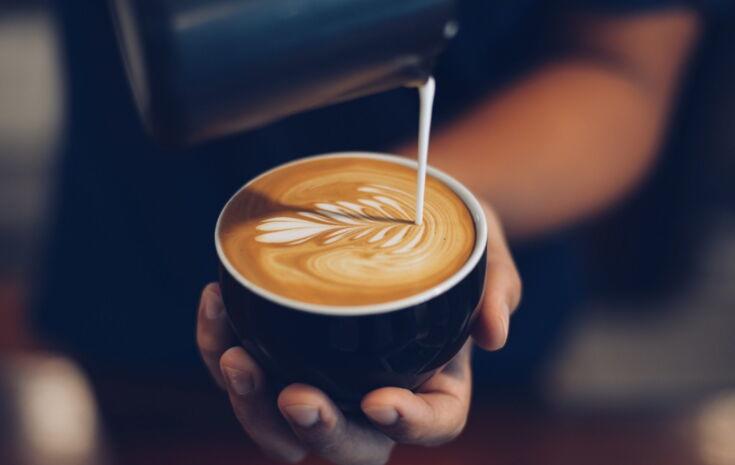 Barista verziert Cappuccino mit Latte Art