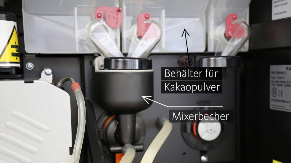 Innenleben eines Kaffeevollautomats mit Mixerbecher und Behälter