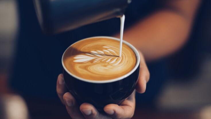 Barista verziert Cappuccino mit Latte Art